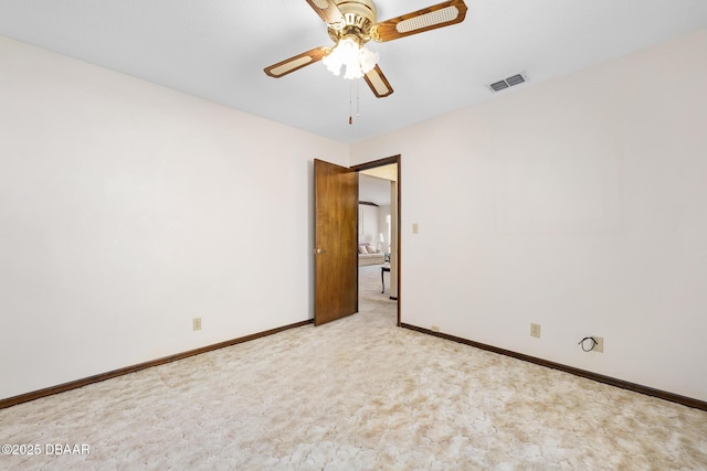 empty room featuring ceiling fan and light colored carpet