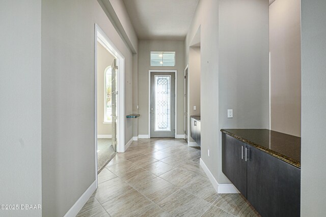 entryway featuring light tile patterned flooring and baseboards