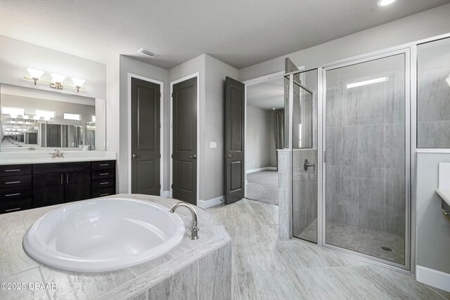 full bathroom featuring visible vents, baseboards, a garden tub, vanity, and a shower stall