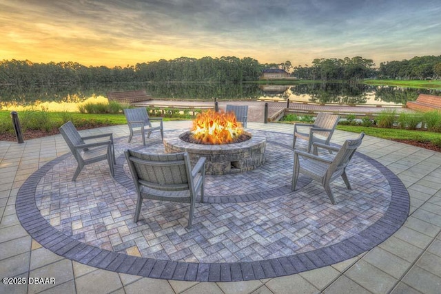 view of patio with an outdoor fire pit and a water view