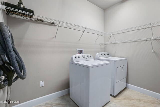 washroom with laundry area, baseboards, and separate washer and dryer