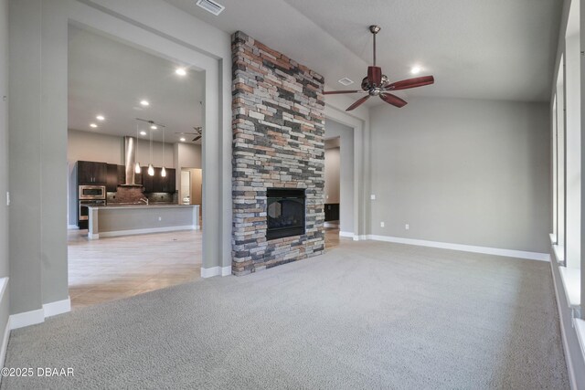 unfurnished living room featuring light carpet, a fireplace, baseboards, and a ceiling fan