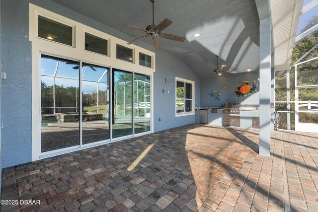 view of patio / terrace with a grill, an outdoor kitchen, and a ceiling fan