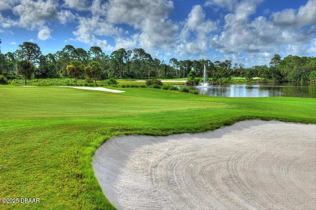 view of community with a yard, golf course view, and a water view