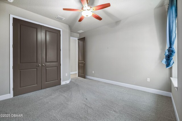 unfurnished bedroom with a closet, light colored carpet, visible vents, a ceiling fan, and baseboards