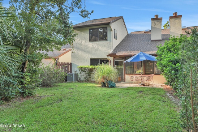 back of house with a lawn and a patio area