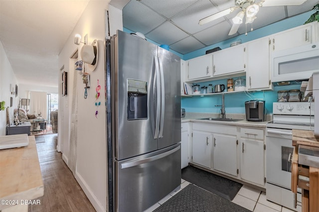 kitchen with white appliances, light hardwood / wood-style floors, white cabinetry, and sink