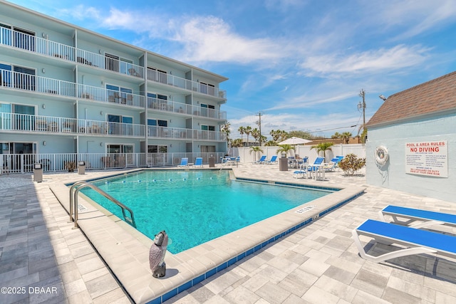 community pool featuring a patio area and fence