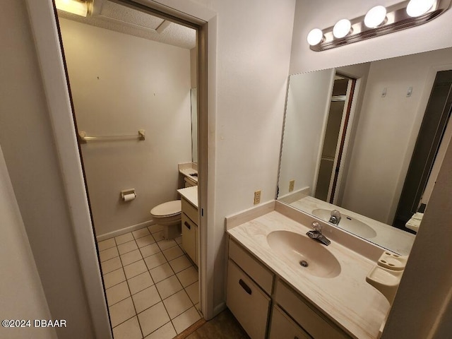 bathroom with toilet, vanity, and tile patterned floors