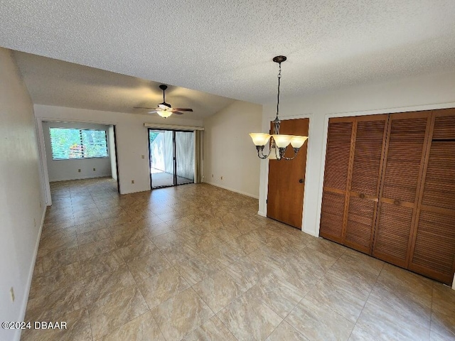 interior space with ceiling fan with notable chandelier and a textured ceiling