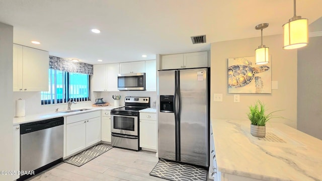 1275 Ocean Shore Blvd Unit 206, Ormond Beach, FL 32176 - kitchen featuring appliances with stainless steel finishes, a sink, white cabinetry, recessed lighting, and pendant lighting