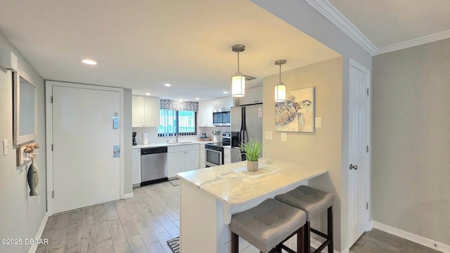 1275 Ocean Shore Blvd Unit 206, Ormond Beach, FL 32176 - kitchen featuring stainless steel appliances, light wood finished floors, a sink, a peninsula, and white cabinets