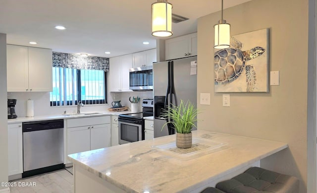 1275 Ocean Shore Blvd Unit 206, Ormond Beach, FL 32176 - kitchen featuring stainless steel appliances, a sink, a peninsula, white cabinetry, and recessed lighting