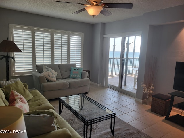 tiled living room featuring ceiling fan and a textured ceiling