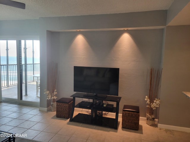 tiled living room with a water view and a textured ceiling