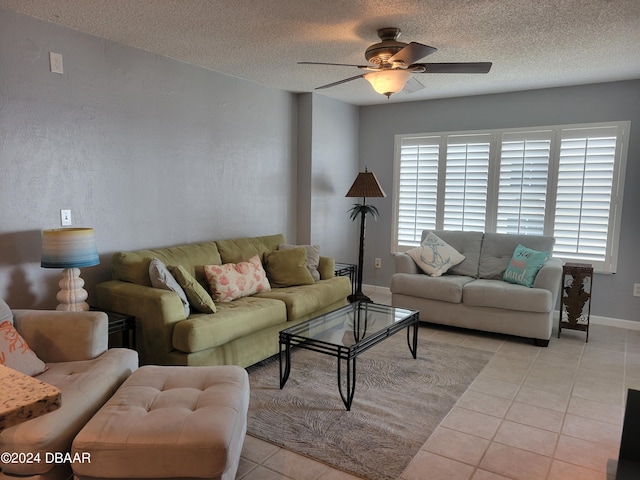 living room with light tile patterned flooring, ceiling fan, and a textured ceiling