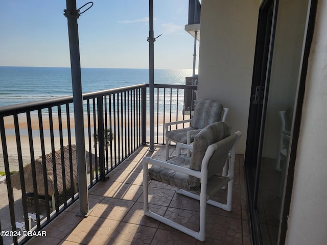 balcony featuring a beach view and a water view