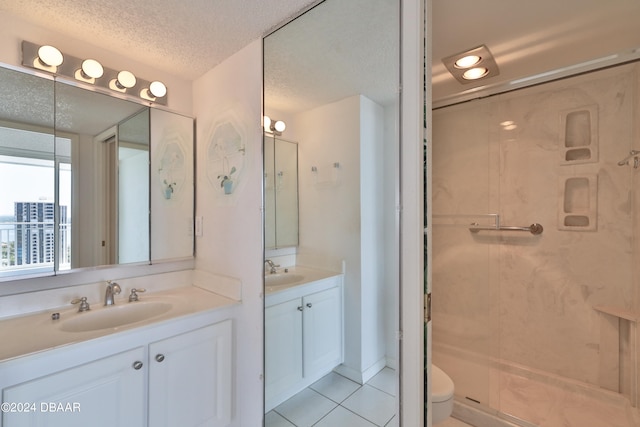 bathroom with toilet, a shower with door, tile patterned flooring, a textured ceiling, and vanity