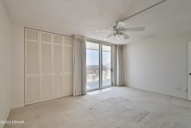 unfurnished bedroom featuring a textured ceiling, light colored carpet, ceiling fan, and access to exterior