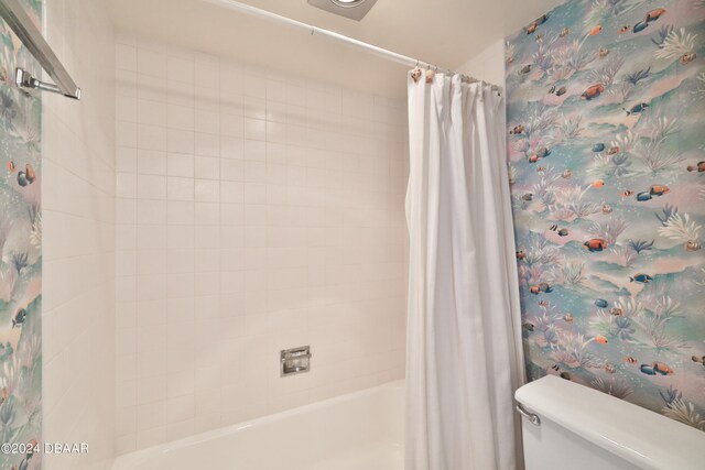 bathroom with toilet and shower / tub combo