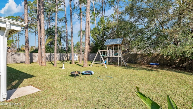 view of yard with a playground and a fire pit