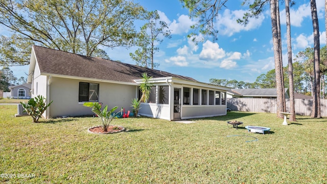 exterior space featuring an outdoor fire pit, a sunroom, and a front yard