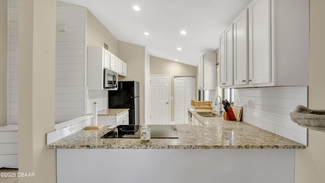 kitchen with light stone counters, sink, black appliances, and white cabinets