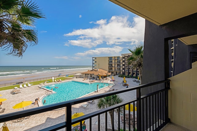 view of pool featuring a water view and a beach view