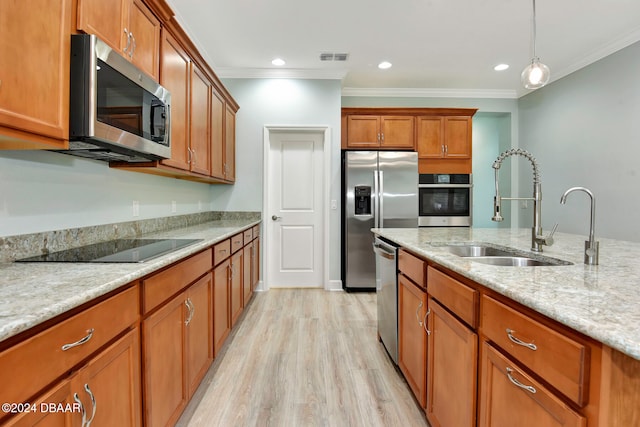 kitchen featuring light stone counters, ornamental molding, stainless steel appliances, sink, and light hardwood / wood-style flooring