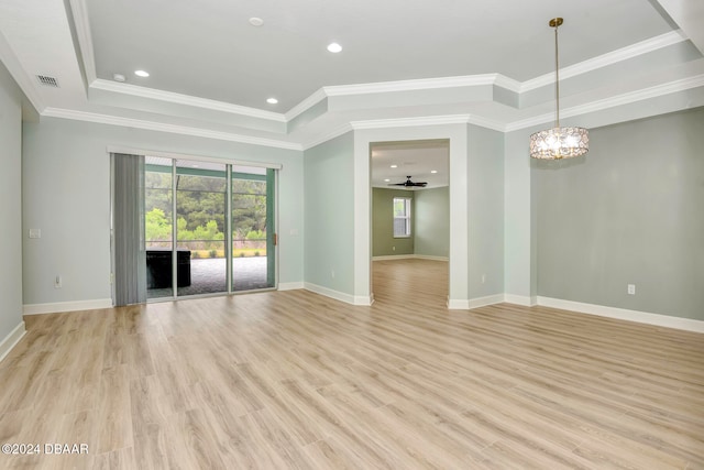 empty room with ceiling fan with notable chandelier, light hardwood / wood-style floors, a raised ceiling, and ornamental molding