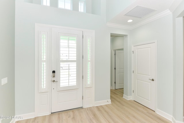 entrance foyer with crown molding and light hardwood / wood-style floors