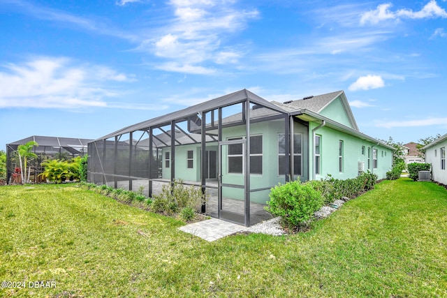 back of house featuring a lanai and a yard