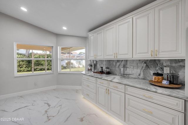 620 Middlebury Loop, New Smyrna Beach, FL 32168 - kitchen featuring decorative backsplash, light marble finish flooring, white cabinets, recessed lighting, and light stone counters