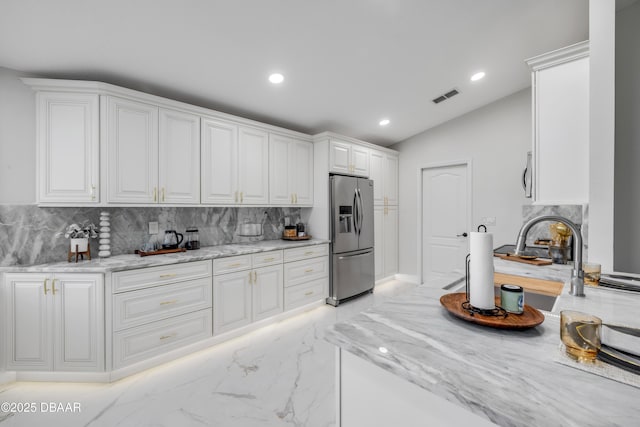620 Middlebury Loop, New Smyrna Beach, FL 32168 - kitchen featuring stainless steel fridge, tasteful backsplash, light marble finish floors, white cabinetry, and recessed lighting
