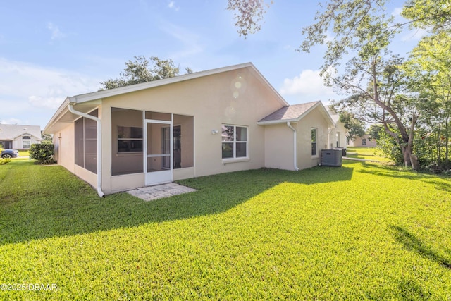 620 Middlebury Loop, New Smyrna Beach, FL 32168 - rear view of house with stucco siding, a sunroom, and a yard