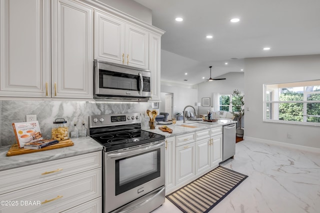 620 Middlebury Loop, New Smyrna Beach, FL 32168 - kitchen with appliances with stainless steel finishes, recessed lighting, light marble finish flooring, backsplash, and lofted ceiling