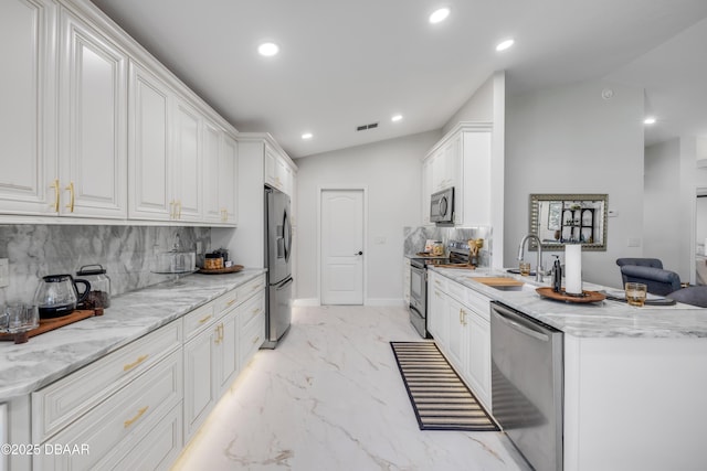 620 Middlebury Loop, New Smyrna Beach, FL 32168 - kitchen with appliances with stainless steel finishes, recessed lighting, tasteful backsplash, light marble finish floors, and white cabinetry