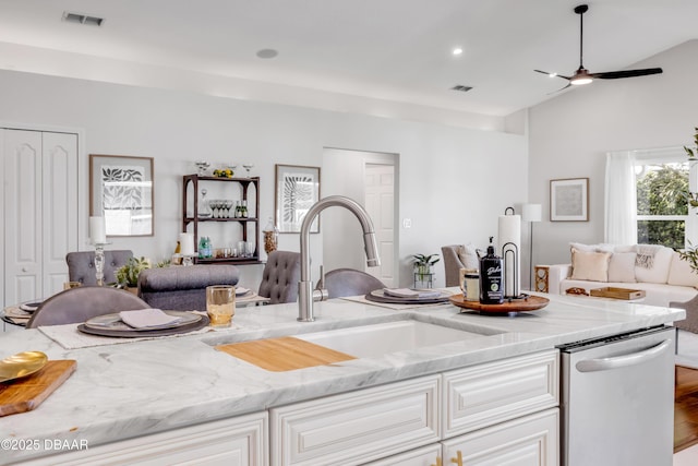 620 Middlebury Loop, New Smyrna Beach, FL 32168 - kitchen with open floor plan, stainless steel dishwasher, light stone countertops, white cabinets, and high vaulted ceiling