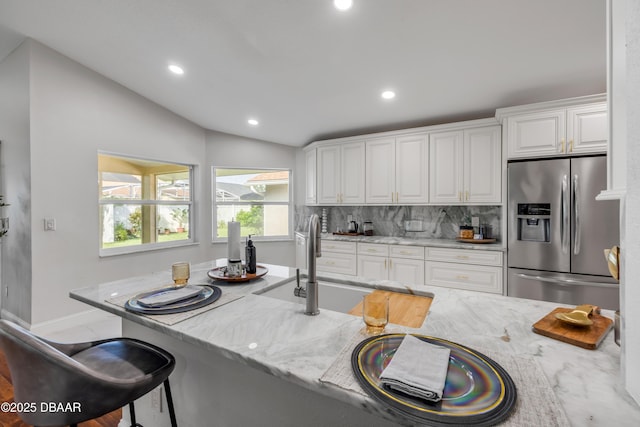 620 Middlebury Loop, New Smyrna Beach, FL 32168 - kitchen featuring stainless steel fridge, recessed lighting, light stone counters, white cabinets, and decorative backsplash
