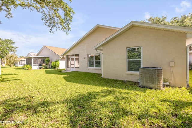620 Middlebury Loop, New Smyrna Beach, FL 32168 - rear view of property with a sunroom, stucco siding, and a lawn