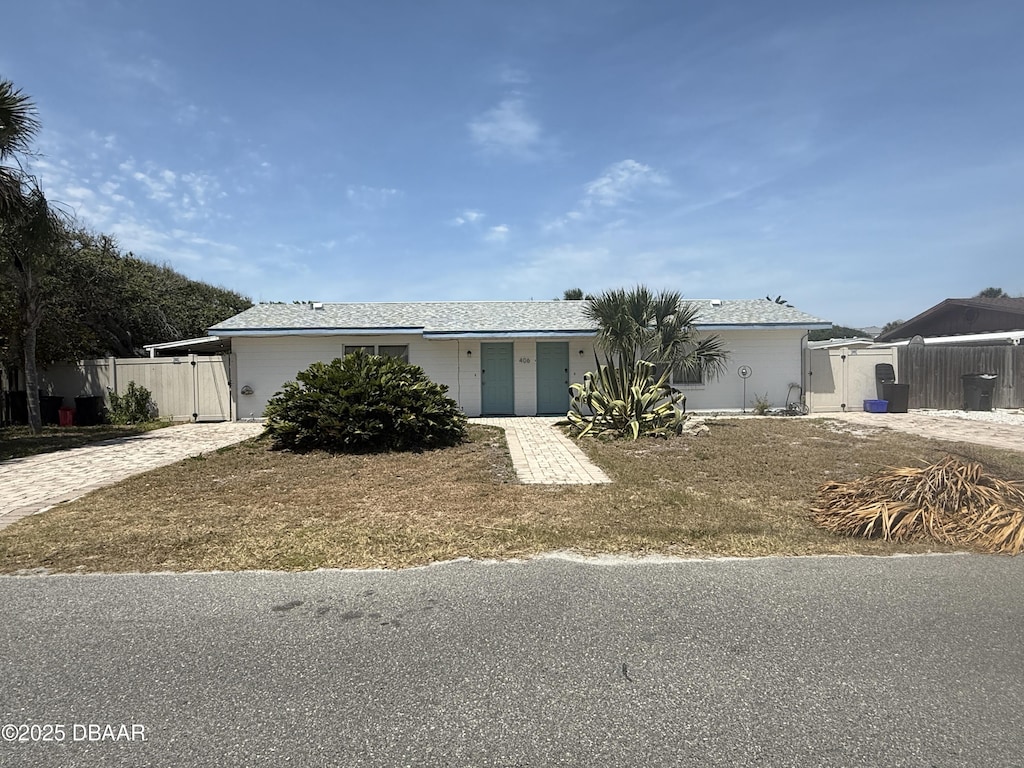 ranch-style home with fence and a gate