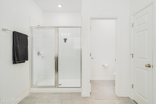 bathroom featuring tile patterned flooring, an enclosed shower, and toilet