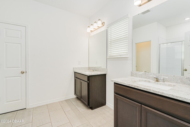 bathroom featuring tile patterned flooring, vanity, and a shower with door