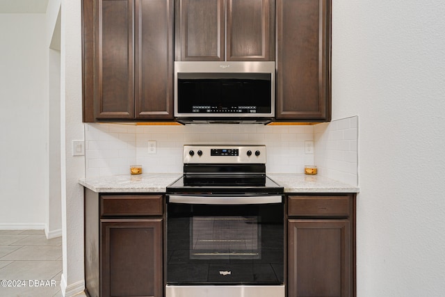 kitchen with light stone countertops, backsplash, and appliances with stainless steel finishes