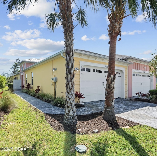 1024 Sea Shell Ct, Daytona Beach, FL 32124 - view of home's exterior featuring stucco siding, decorative driveway, and a garage