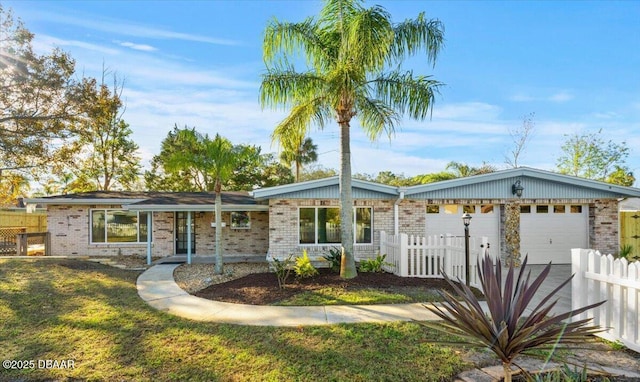 ranch-style house featuring covered porch, a front yard, and a garage