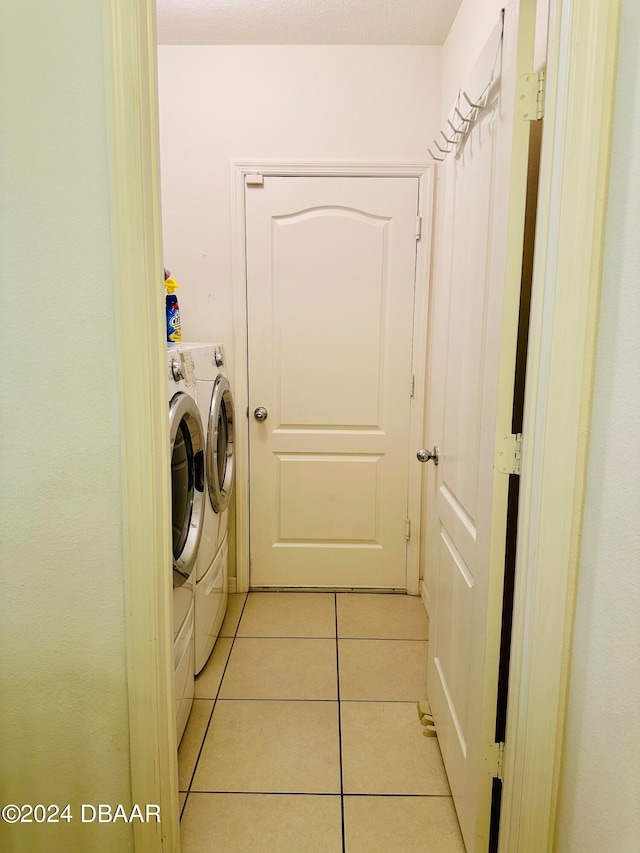 laundry room featuring washer and dryer and light tile patterned flooring