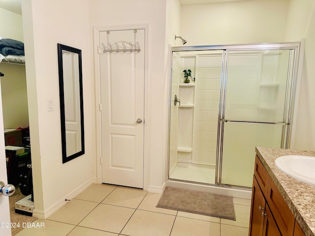 bathroom with walk in shower, vanity, and tile patterned floors