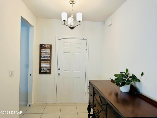 tiled entrance foyer featuring a notable chandelier