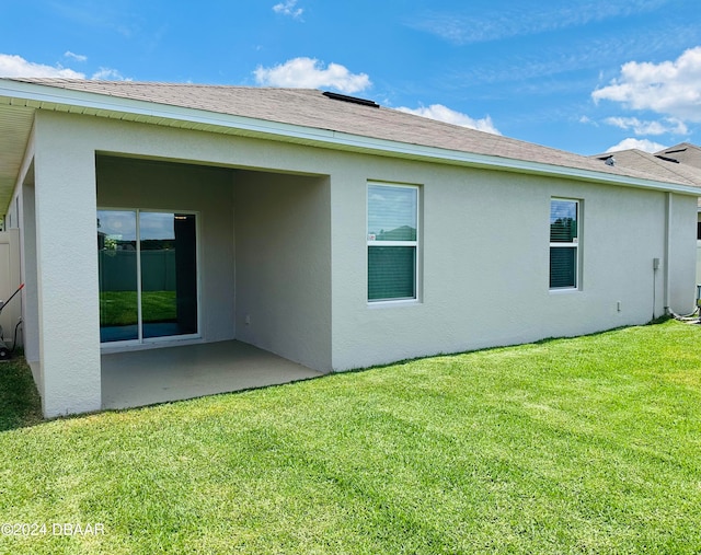 back of house featuring a yard and a patio area